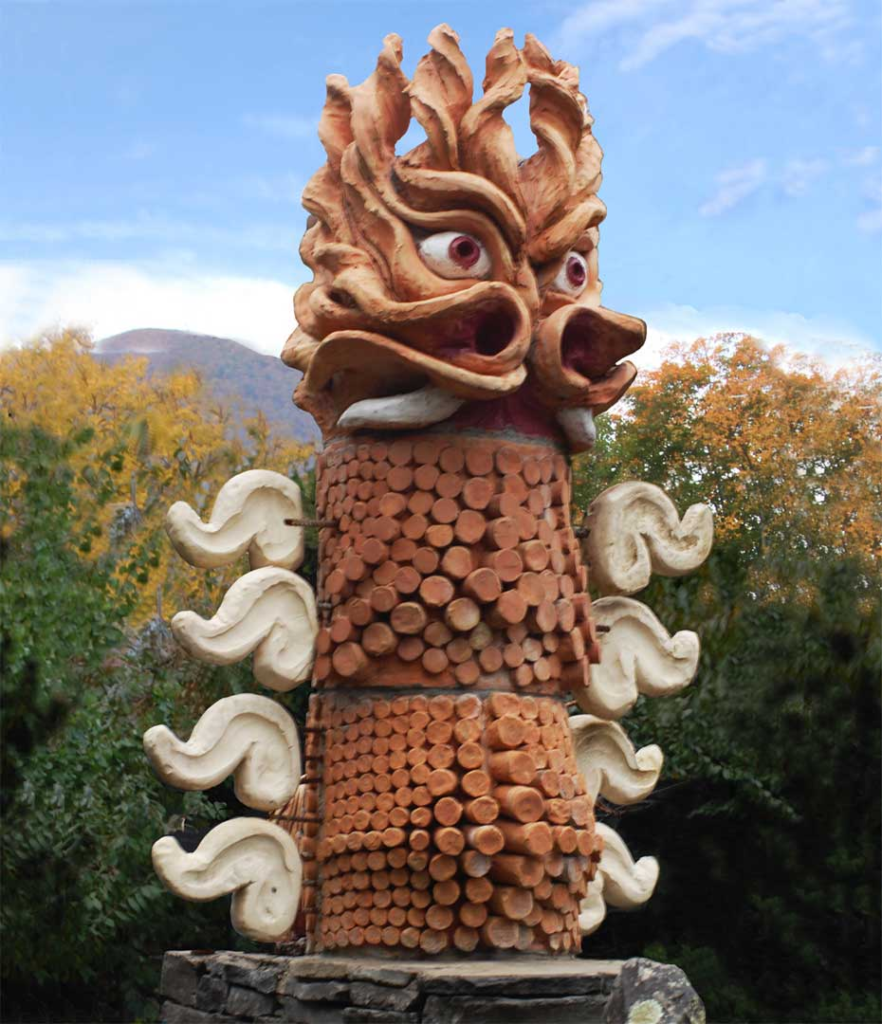 Close up view of Beowulf’s Dragon, a monumental 11' three dimensional ceramic stoneware sculpture with iron rich sandstone like surface, anchored on a Catskill Mountain bluestone base.