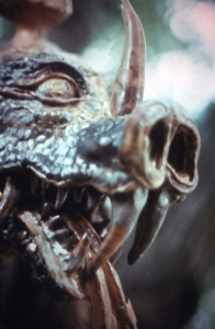 Close‑up of Beowulf’s Dragon head, a ceramic stoneware sculpture commissioned by John Gardner in 1972, showing the Wyrm’s gaze in detailed relief.