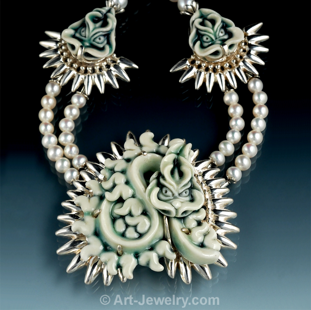 Close‑up of the hand‑carved porcelain coiled dragon talisman showing sculptural detail and the custom sterling silver bezel.